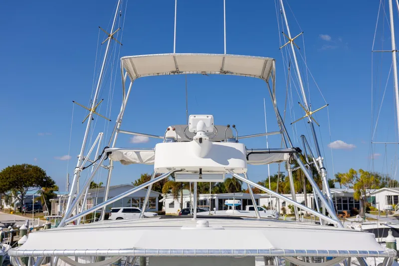 Slide: The Image of 1997 Tiara Yachts 3500 Express boat with radar and antennas, docked under clear blue sky. - 18