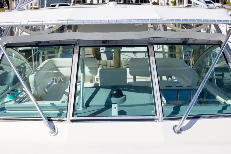 Slide: The Image of 1997 Tiara Yachts 3500 Express cockpit with white seating and clear windshield. - 19