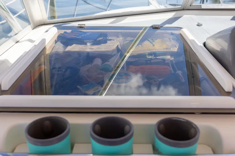 Slide: The Image of 1997 Tiara Yachts 3500 Express cockpit with storage compartment and cup holders. - 23