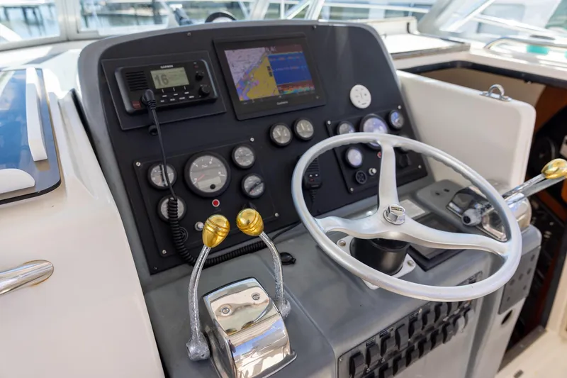 Slide: The Image of 1997 Tiara Yachts 3500 Express helm with steering wheel and navigation controls. - 24