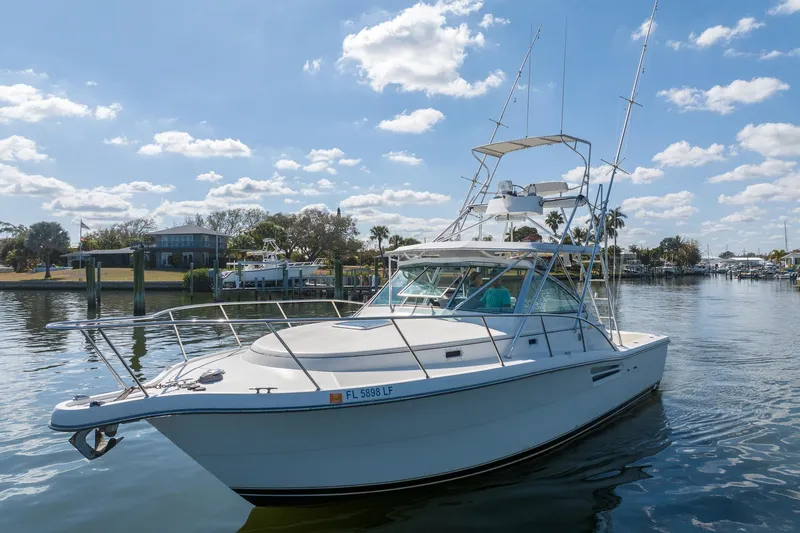 Slide: The Image of 1997 Tiara Yachts 3500 Express cruising on a sunny day, dockside view. - 3
