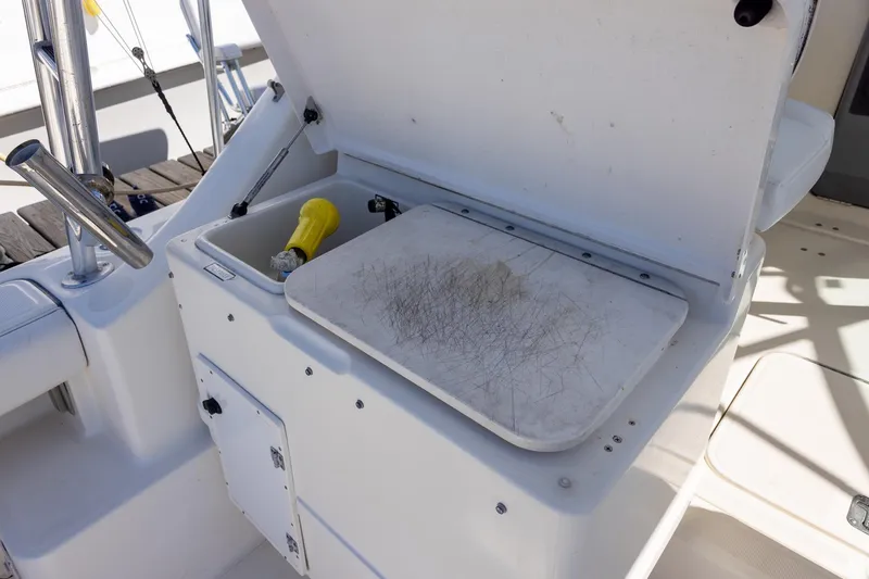 Slide: The Image of 1997 Tiara Yachts 3500 Express boat with open storage compartment and cutting board. - 32