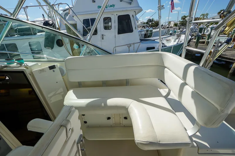 Slide: The Image of 1997 Tiara Yachts 3500 Express interior with white seating at marina. - 38