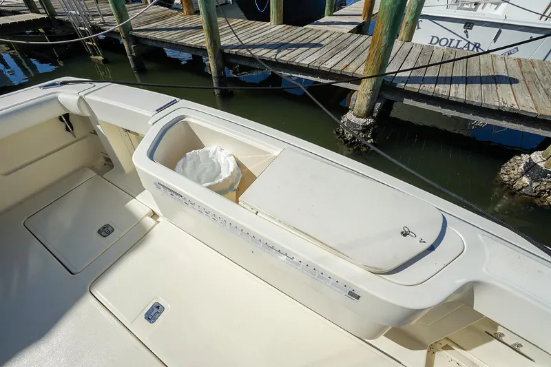 Slide: The Image of 1997 Tiara Yachts 3500 Express boat deck with storage compartment and dock view. - 42
