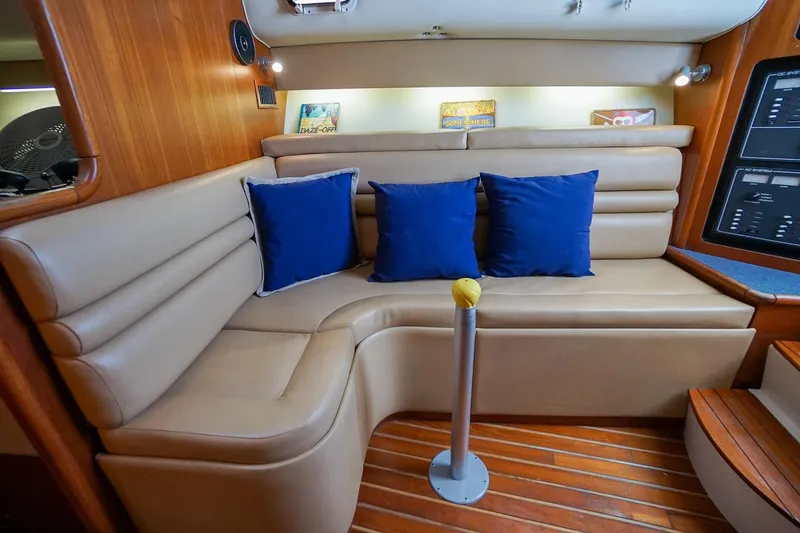 Slide: The Image of Luxurious 1997 Tiara Yachts 3500 Express interior with beige seating and blue cushions. - 47
