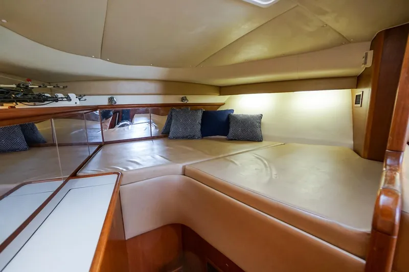 Slide: The Image of 1997 Tiara Yachts 3500 Express cabin interior with cushioned seating and decorative pillows. - 49