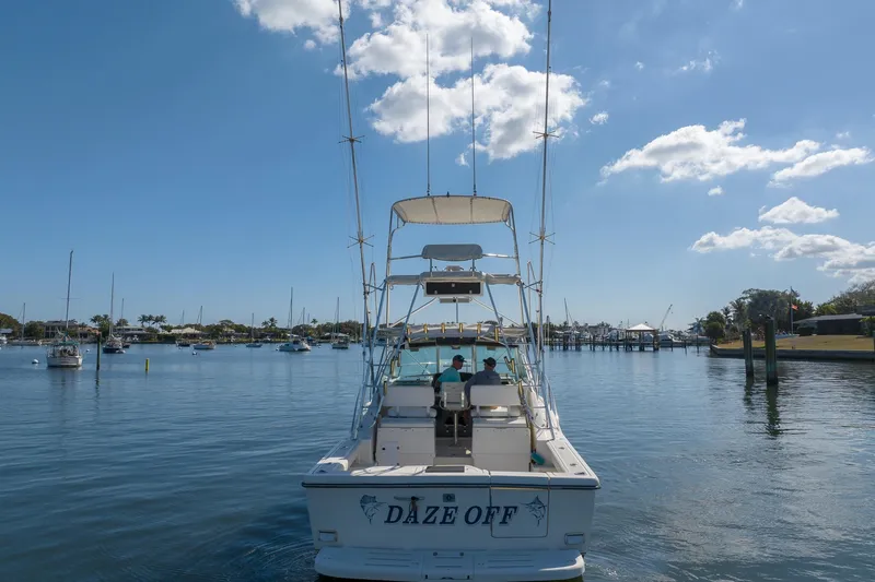 Slide: The Image of 1997 Tiara Yachts 3500 Express boat named "Daze Off" on calm water under blue sky. - 5