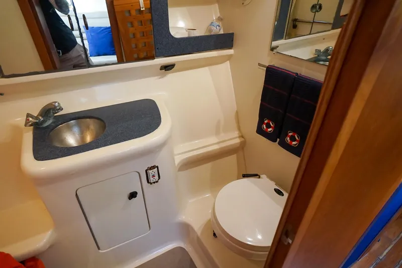 Slide: The Image of 1997 Tiara Yachts 3500 Express bathroom with sink, toilet, and nautical-themed towels. - 50