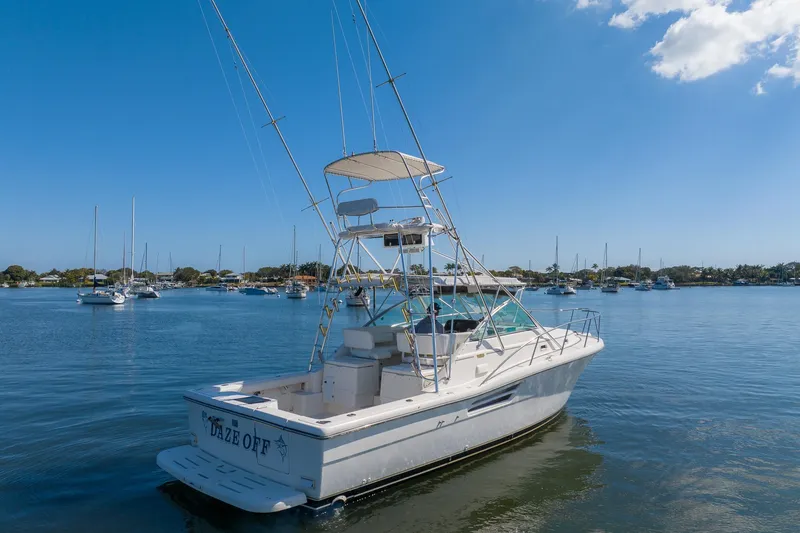 Slide: The Image of 1997 Tiara Yachts 3500 Express boat on calm water, clear blue sky background. - 6