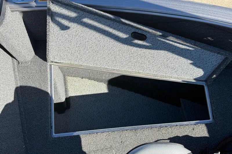 Slide: The Image of 2020 Lund 1875 Impact XS boat storage compartment with open lid, showing interior details. - 15