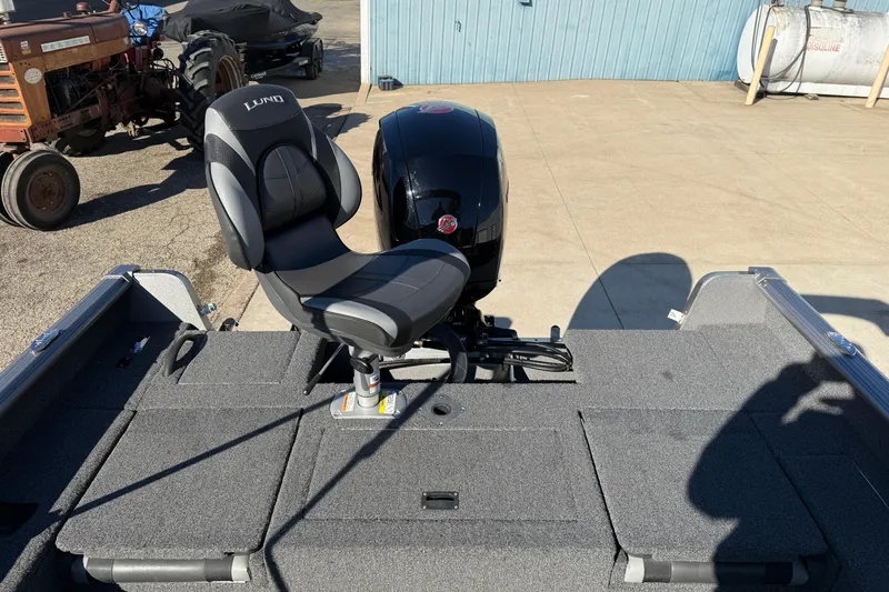 Slide: The Image of 2020 Lund 1875 Impact XS boat with swivel seat and motor, parked outdoors. - 35