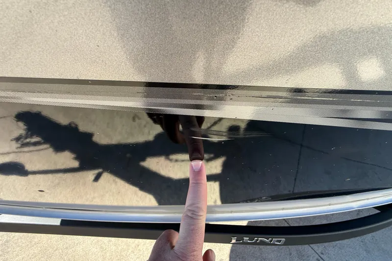 Slide: The Image of Finger pointing at scratch on 2020 Lund 1875 Impact XS boat hull. - 40