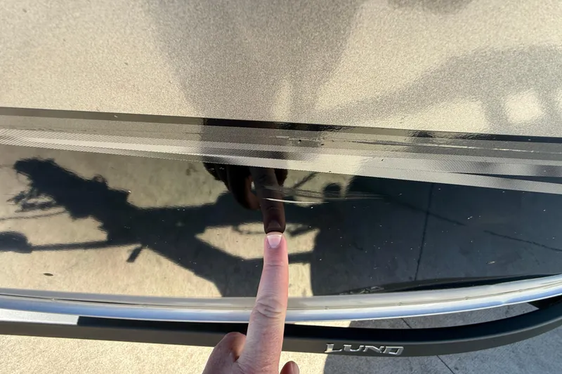 Slide: The Image of Finger pointing at scratch on 2020 Lund 1875 Impact XS boat hull. - 41