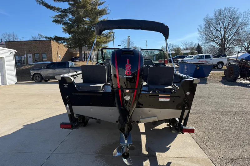 Slide: The Image of 2020 Lund 1875 Impact XS boat with 150 HP engine, parked outdoors. - 6