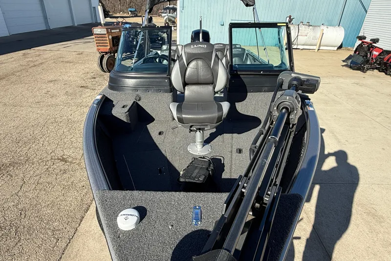 Slide: The Image of 2020 Lund 1875 Impact XS boat with seating and equipment, parked outdoors. - 9