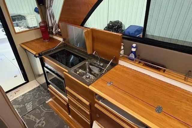 Slide: The Image of 2022 Cutwater C-30 Sedan interior kitchen with wooden cabinetry and modern appliances. - 15