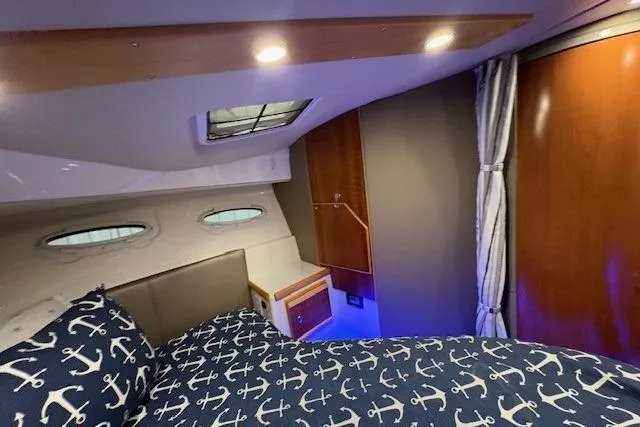 Slide: The Image of 2022 Cutwater C-30 Sedan cabin interior with nautical-themed bedding and ambient lighting. - 22