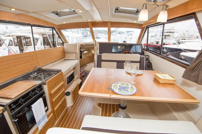Slide: The Image of Manufacturer Provided Image: Interior of 2022 Cutwater C-30 Sedan yacht with dining table and kitchen area. - 6