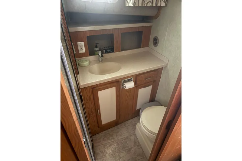 Slide: The Image of 1987 Mainship 36 Nantucket Sedan bathroom with wood cabinetry and compact design. - 12