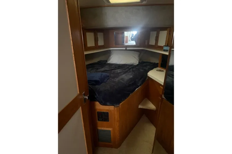 Slide: The Image of 1987 Mainship 36 Nantucket Sedan cabin interior with cozy bed and wooden cabinetry. - 16