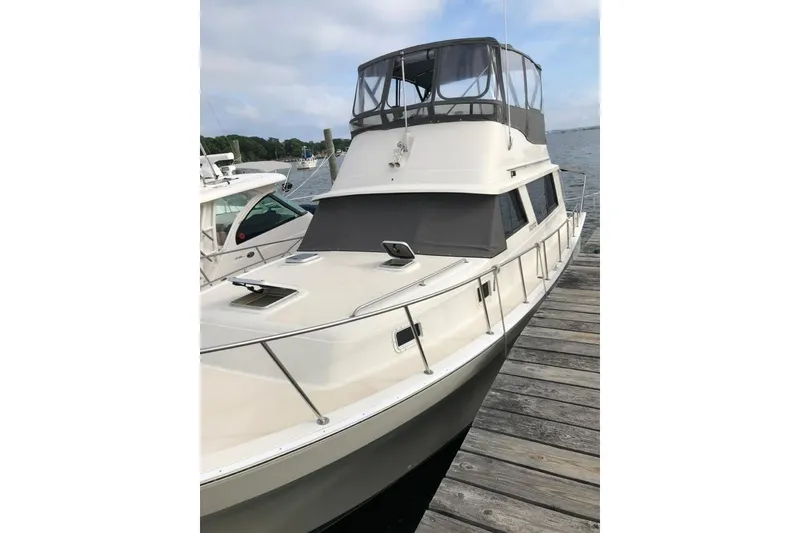 Slide: The Image of 1987 Mainship 36 Nantucket Sedan docked, showcasing sleek design and spacious deck. - 3