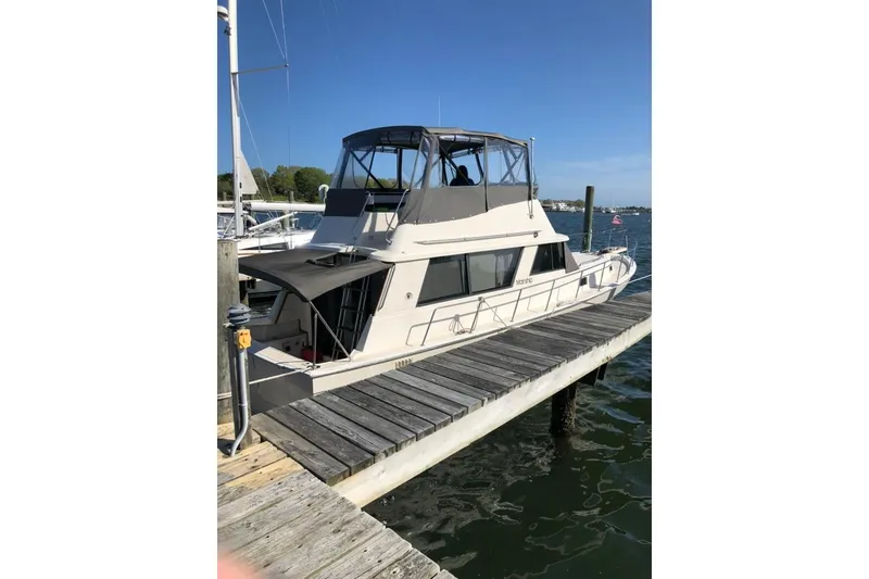 Slide: The Image of 1987 Mainship 36 Nantucket Sedan docked at a marina on a sunny day. - 4