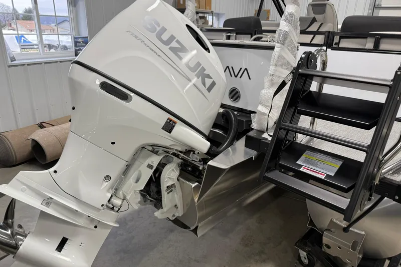 Slide: The Image of 2026 Avalon LSZ Quad Lounge boat with Suzuki outboard motor in a showroom. - 7