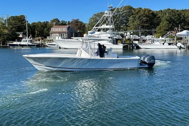 Slide: The Image of 2017 Regulator 31 boat cruising in a marina with clear blue water and trees in the background. - 2