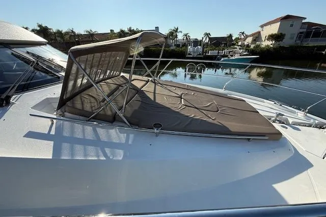 Slide: The Image of 2015 Prestige 500 yacht docked by waterfront homes, surrounded by lush greenery. - 10