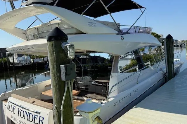 Slide: The Image of Luxury 2015 Prestige 500 yacht docked in urban marina, reflecting on calm water. - 12