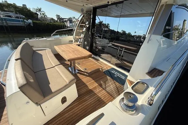 Slide: The Image of 2015 Prestige 500 yacht with sunshade, docked in a serene waterfront setting. - 16