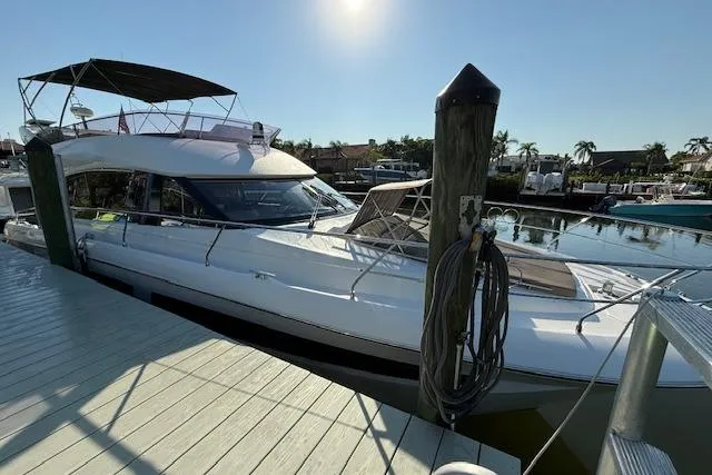 Slide: The Image of 2015 Prestige 500 yacht docked in a scenic marina with palm trees and waterfront homes. - 5