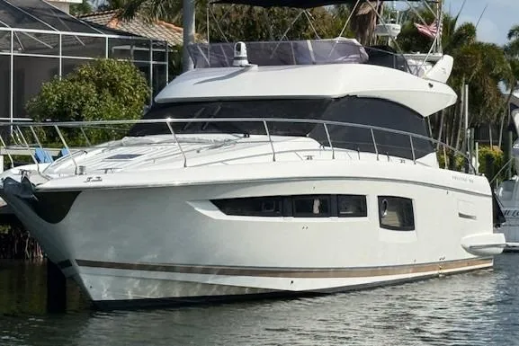 Slide: The Image of 2015 Prestige 500 yacht docked by waterfront homes, featuring sleek design and modern amenities. - 6