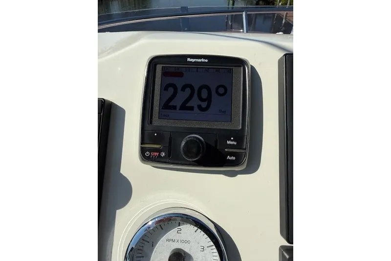 Slide: The Image of Flybridge view of 2015 Prestige 500 yacht, featuring helm and sunbathing area, docked by waterfront homes. - 70