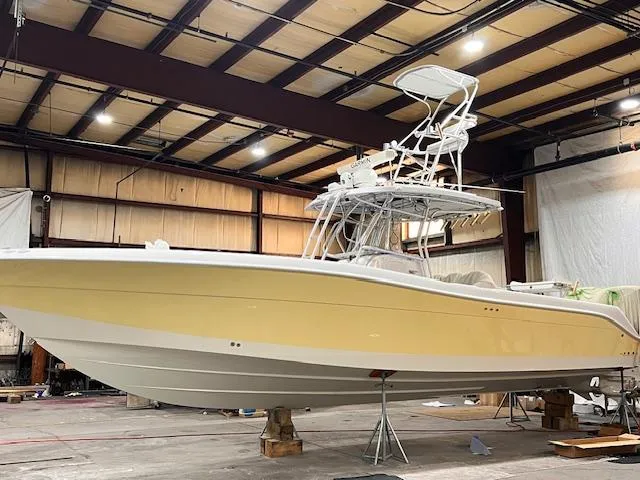 Slide: The Image of 2005 Hydra-Sports Vector 3300 CC boat in a warehouse, yellow hull, elevated on stands. - 7
