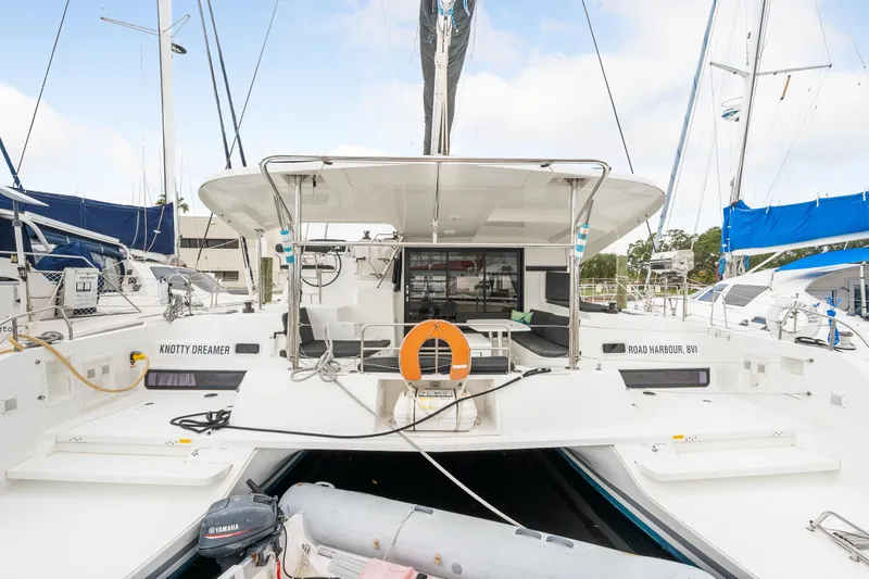 Slide: The Image of 2018 Lagoon 42 catamaran with spacious deck and dinghy, docked at marina. - 20