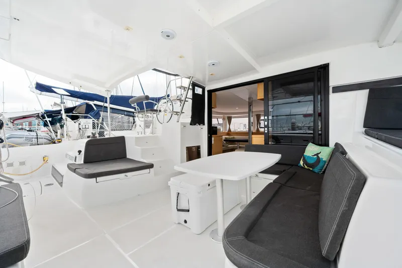 Slide: The Image of Lagoon 42 catamaran 2018 model, spacious cockpit with seating and dining area, docked at marina. - 25