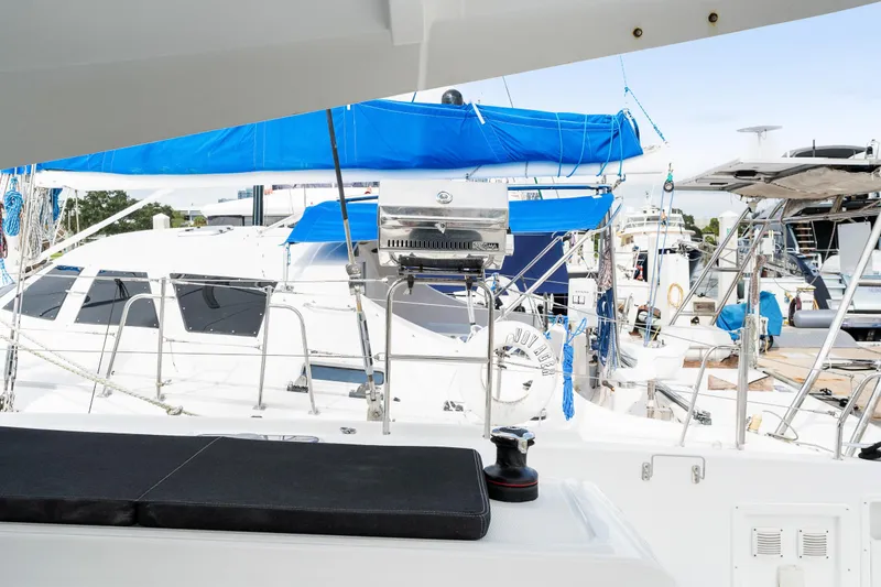 Slide: The Image of Lagoon 42 catamaran 2018 model docked, featuring a blue canopy and outdoor seating. - 28