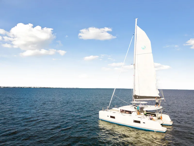 Slide: The Image of 2018 Lagoon 42 catamaran sailing on a clear blue sea under a sunny sky. - 8