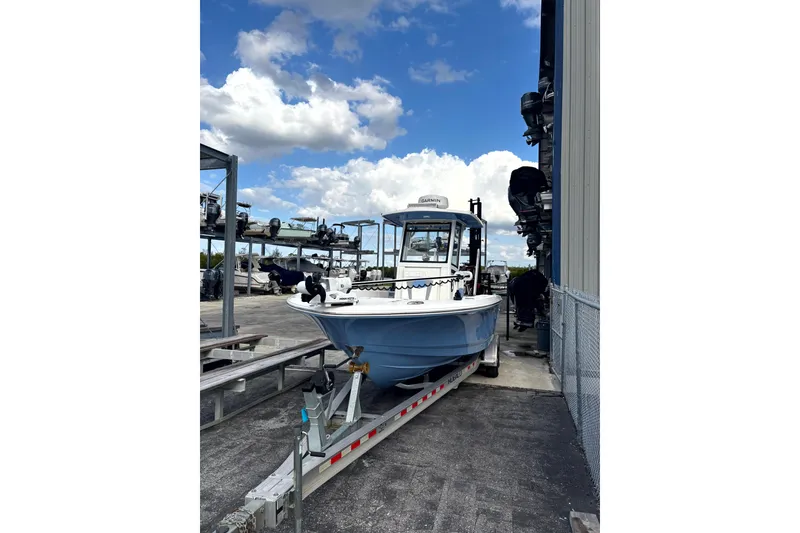 Slide: The Image of 2023 Robalo 266 Cayman boat on trailer under blue sky. - 12