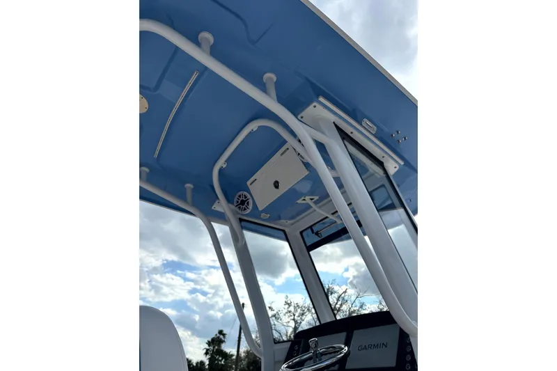 Slide: The Image of 2023 Robalo 266 Cayman boat interior with blue canopy and Garmin equipment. - 16