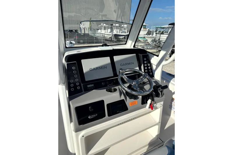 Slide: The Image of 2023 Robalo 266 Cayman boat dashboard with Garmin navigation system and steering wheel. - 21