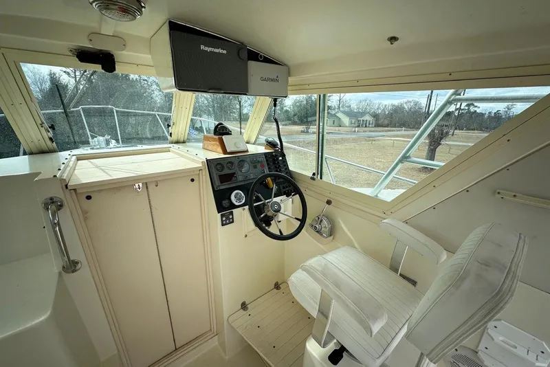 Slide: The Image of 2000 Albin 28 Tournament Express helm with steering wheel, navigation equipment, and captain's chair. - 12