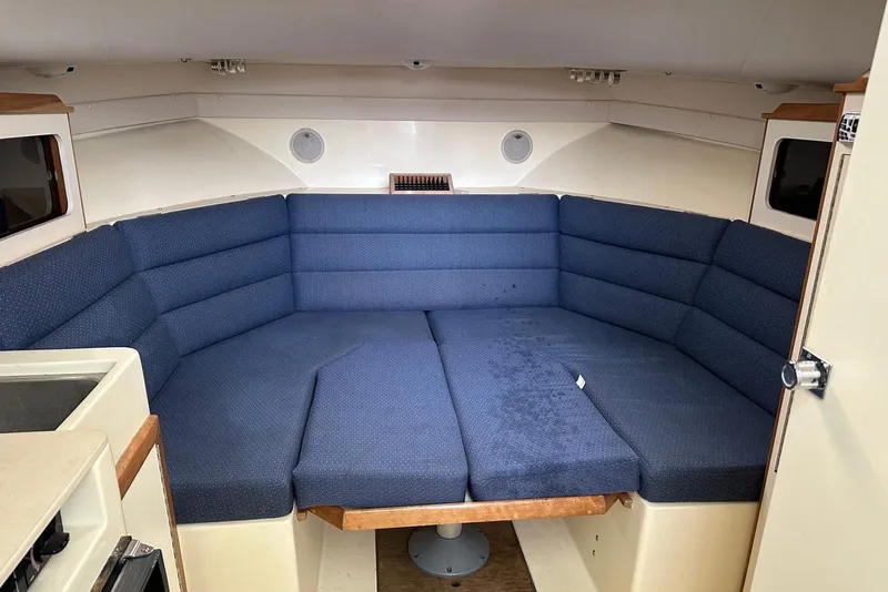 Slide: The Image of Interior of a 2000 Albin 28 Tournament Express with blue cushioned seating. - 19