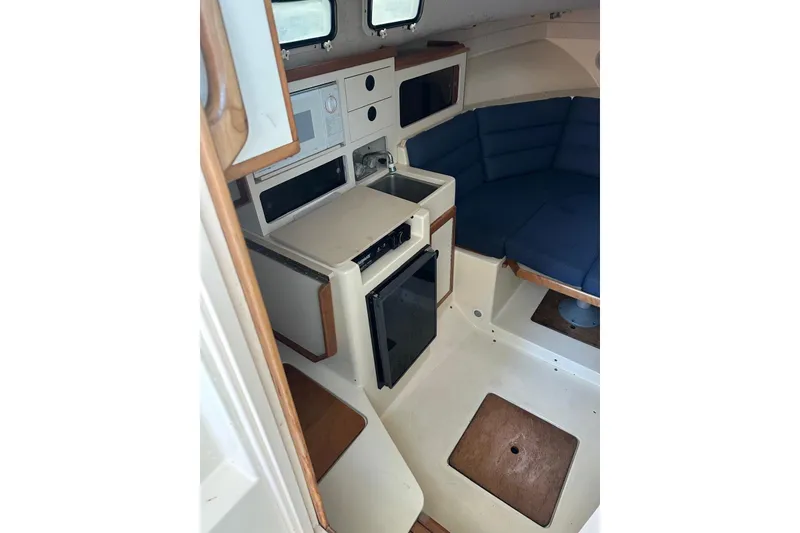 Slide: The Image of Interior of 2000 Albin 28 Tournament Express with kitchenette and seating area. - 21