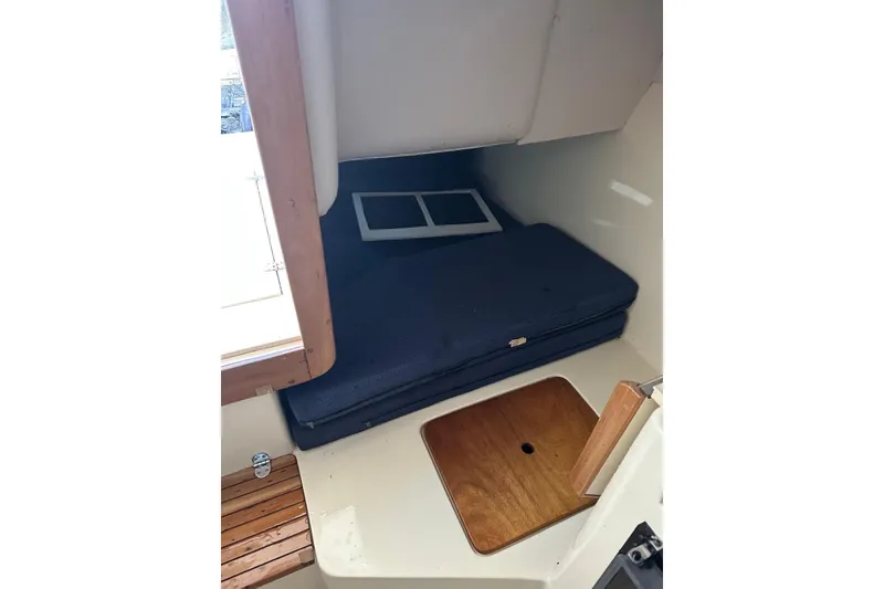 Slide: The Image of 2000 Albin 28 Tournament Express cabin interior with blue cushion and wooden accents. - 22