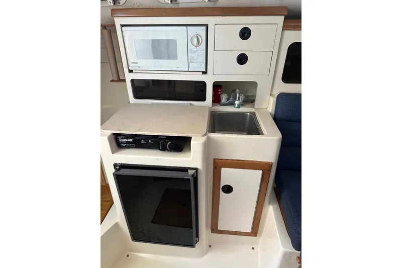 Slide: The Image of Compact galley in 2000 Albin 28 Tournament Express with microwave, sink, and storage. - 23