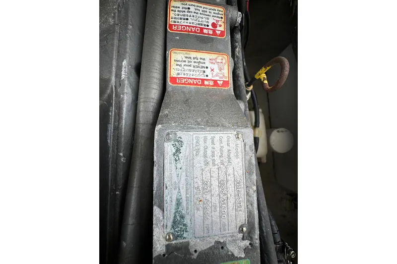 Slide: The Image of Engine compartment of a 2000 Albin 28 Tournament Express with warning labels and specifications. - 32