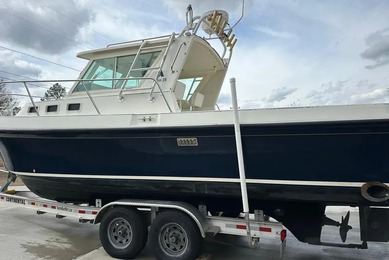 Slide: The Image of 2000 Albin 28 Tournament Express boat on trailer under cloudy sky. - 5