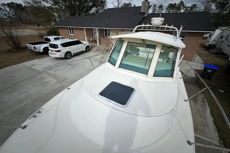 Slide: The Image of 2000 Albin 28 Tournament Express boat parked in driveway near house and vehicles. - 6